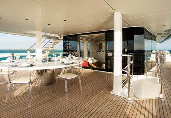 the upper deck aft of motor yacht HOME with alfresco dining area overlooking the water