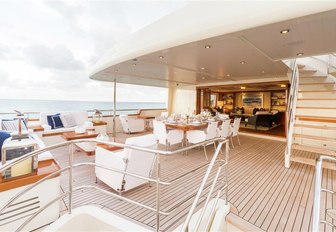 the main deck aft of charter yacht fabulous character with alfresco dining table and peppered with luxury seating
