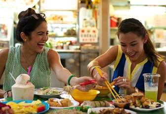 Two charter guests enjoying some Singapore street food