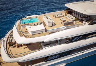 large pool, seating and shaded dining area on the sundeck of luxury yacht Spectre