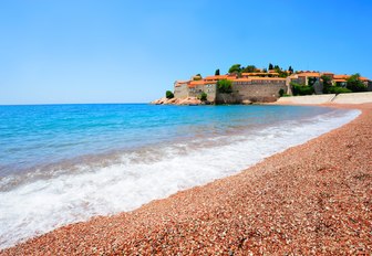 pebbly beach and blue waters of Sveti Stefan Island in Montenegro