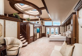 master suite with bed, skylight, seating areas and stairs to an upper level on board charter yacht CALYPSO