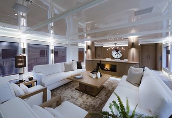 salon with white sofas and fireplace on board luxury yacht Liquid Sky