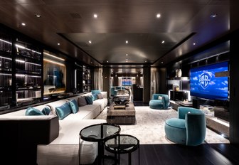 large white sofa faces huge TV screen in the main salon aboard motor yacht SOLO