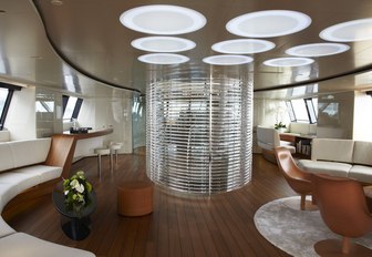 main salon of luxury charter yacht panthalassa with staircase and lighting panels overhead