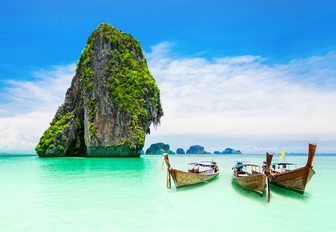 Boats on the water in the Phi Phi Islands, with limestone rock in background