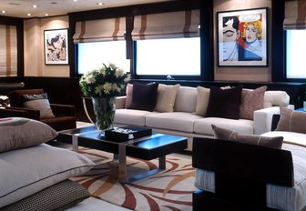 Sofas and table on Illusion I yacht with windows and artwork behind