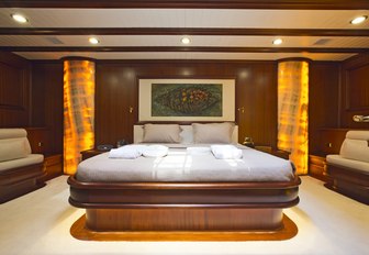 large bed with onyx pillars in master suite aboard luxury yacht REGINA 