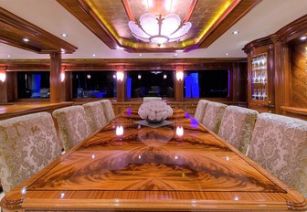 rich wooden dining table in the main salon aboard charter yacht EXCELLENCE