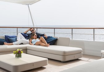 two guests unwind on the sunpads on the sundeck of charter yacht GO