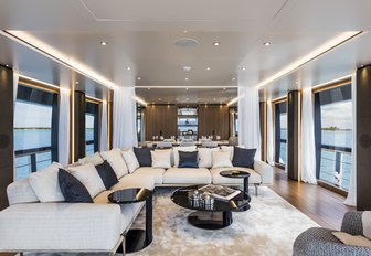 seating area flanked by full-length windows in the main salon aboard motor yacht Vista Blue