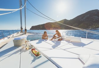 guest in the Jacuzzi aboard sailing yacht Q chats to a guest on the sunpads nearby