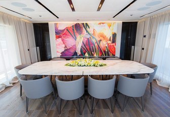 formal dining area looked over by contemporary artwork aboard superyacht OURANOS