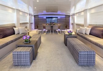 Sofas and dining table in background in main salon of superyacht Tropicana