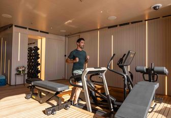 Superyacht charter SYMMETRY guest using gym equipment