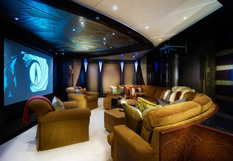 Interior cinema area onboard charter yacht WHISPER with large sofa and wall-mounted screen