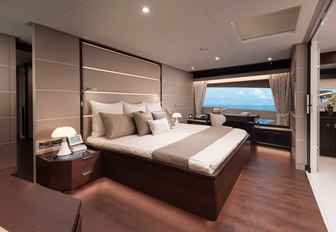 the spacious master cabin inside charter yacht impatient IV with a grand window that opens up to the Mediterranean 