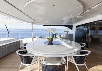 circular dining table on the upper deck aft of luxury yacht Quinta Essentia