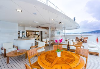 outdoor area with tables and lounging options on board charter yacht LEGEND