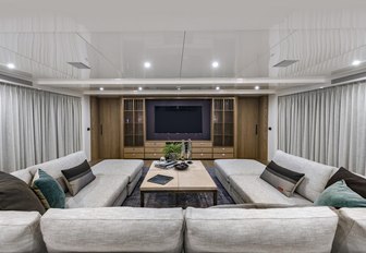 U-shaped sofa faces large TV on board charter yacht Liquid Sky