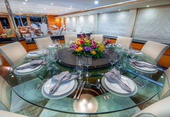 large round glass table in the indoor dining area of luxury yacht island heiress 