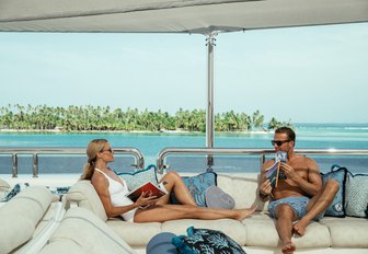 charter guests relax in the seating area on the sundeck of superyacht CALYPSO