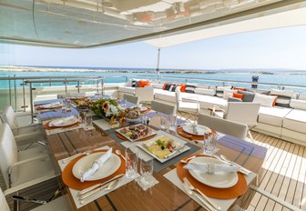 alfresco dining table set for dinner on upper deck aft of motor yacht ROMA