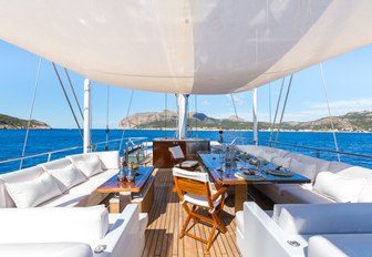 seating and casual dining area on the flybridge of charter yacht Q with Bimini 