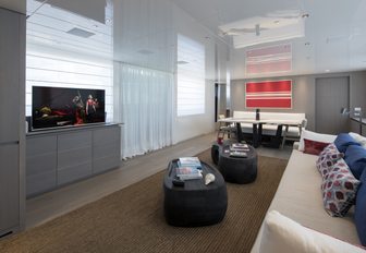 long sofa faces TV in the main salon of luxury yacht Dinaia