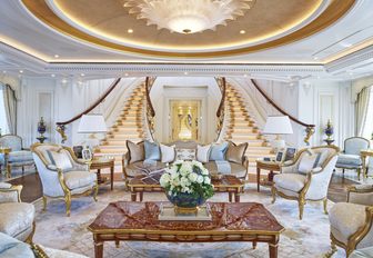Staircase on luxury yacht TIS, with chandelier overhead and main salon in foreground