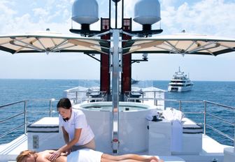 charter guest enjoys a massage on the sundeck of luxury yacht HIGHLANDER