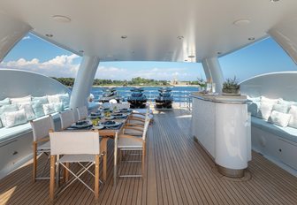 alfresco dining table and bar under the radar arch on the sundeck of luxury yacht La Mirage 