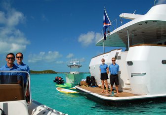 crew stand on swim platform alongside water toys on board superyacht ‘Sweet Escape’