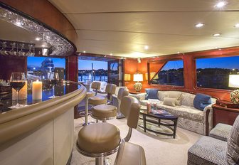 bar with stools alongside seating area in the skylounge of motor yacht ‘Sweet Escape’