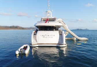 the swim platform and stern of charter yacht Infinity Pacific with tender and waterslide