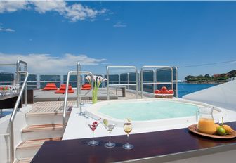 Jacuzzi and bar forward with sun pads beyond on sun deck of superyacht Sai Ram