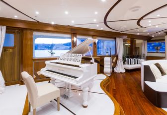 A sleek white grand piano inside superyacht LEGEND