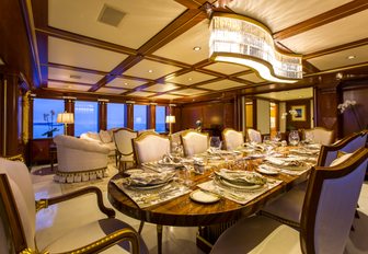 dining table overlooked by a glittering chandelier in the main salon of charter yacht ‘My Seanna’ 