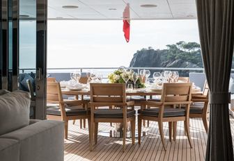 circular wooden dining table on the deck of charter yacht Berco Voyager