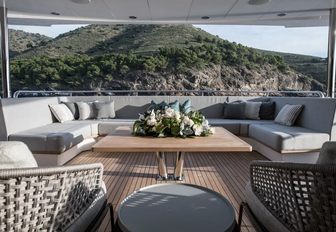 built-in sofas wrap around square coffee table on the deck of luxury yacht Berco Voyager