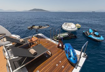 chaise loungers laid out on the swim platform of luxury yacht L’EQUINOX with toys in the water