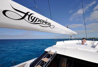 charter guests relaxes on the upper level of charter yacht HYPERION