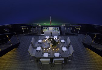 square dining table on the upper deck aft of motor yacht Ocean Emerald 