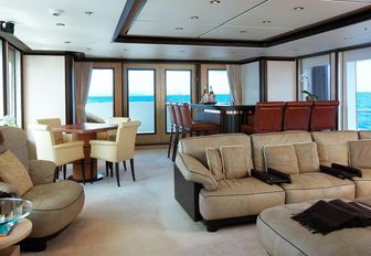 sofa, bar and games table in the main salon aboard motor yacht HARLE 