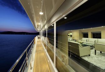 on the side decks of motor yacht ‘Rima II’ as sun sets with view into main salon