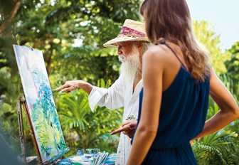 painter roland richardson giving a painting tutorial to a guest at belomond la samanna resort