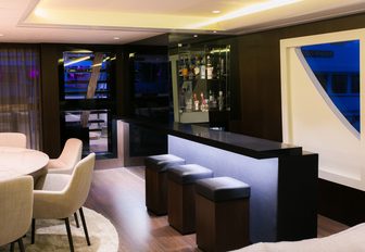sleek bar lights up at night in main salon aboard motor yacht SAHANA 
