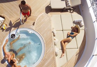guests relax in the Jacuzzi and on the sun pads on the sundeck of motor yacht LIBERTY