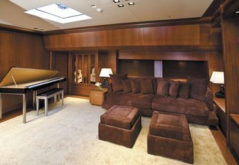sumptuous lower salon with sofa and piano on board sailing yacht ETHEREAL 