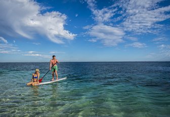 paddle boarders explore the clear, still waters of the Ningaloo Reef in Western Australia